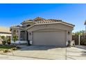 Tan house with a two-car garage, landscaping, and lion statues at 16789 W Taylor St, Goodyear, AZ 85338