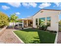 Charming backyard with covered patio, grassy area, and mature trees at 16944 W Coronado Rd, Goodyear, AZ 85395