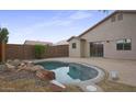 Inviting kidney-shaped pool surrounded by a rock garden at 30689 N Royal Oak Way, San Tan Valley, AZ 85143