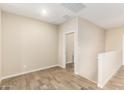 Spacious loft area with neutral walls and wood-look tile floors at 2260 W Harmont Dr, Phoenix, AZ 85021