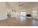 Bright living room with hardwood floors, fireplace, and kitchen island at 19832 N 95Th Ave, Peoria, AZ 85382