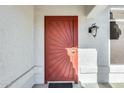 Red metal front door with sunburst design at 15336 W Arzon Way, Sun City West, AZ 85375