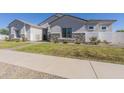 Exterior view of a two-story home, showcasing stone accents and a landscaped yard at 18965 S 196Th Pl, Queen Creek, AZ 85142