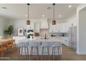 Bright, spacious kitchen featuring white cabinetry, an island with seating, and stainless steel appliances at 4550 N 192Nd Dr, Litchfield Park, AZ 85340