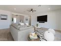 Inviting living area with comfortable seating, a large TV, and ample natural light at 4550 N 192Nd Dr, Litchfield Park, AZ 85340