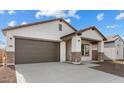 Inviting single-story home with brown garage door, stone accents, and desert landscaping at 23387 W Albeniz Pl, Buckeye, AZ 85326