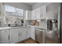 Updated kitchen featuring white cabinets, stainless steel appliances, and tile backsplash at 158 W Commerce Ct, Gilbert, AZ 85233
