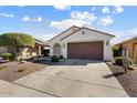 One-story home with brown garage door and landscaped yard at 21613 N 261St Ave, Buckeye, AZ 85396