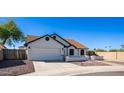 White single story home with a two-car garage and rock landscaping at 19624 N 47Th Ln, Glendale, AZ 85308