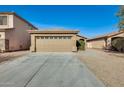 Tan colored house with a two car garage and gravel driveway at 826 E Impreria St, San Tan Valley, AZ 85140