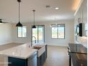 Modern kitchen features a farmhouse sink, white quartz counters and a breakfast bar at 58Xx N Nigal Rd, Casa Grande, AZ 85194