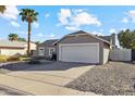 Gray single story home with a two car garage and desert landscaping at 1317 W Monona Dr, Phoenix, AZ 85027