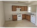 Simple kitchen featuring light wood cabinets and white appliances at 5020 S 25Th Ave, Phoenix, AZ 85041