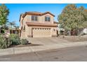 Two-story house with tan exterior, tile roof, and a two-car garage at 6782 W Firebird Dr, Glendale, AZ 85308