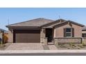 Single-story home with brown garage door, stone accents, and a landscaped front yard at 4638 N 178Th Ln, Goodyear, AZ 85395