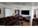 Living room with brown sofa, wicker chairs, and TV at 9333 E University Dr # 89, Mesa, AZ 85207