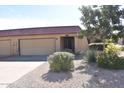 Front view of the house with a two-car garage and well-maintained landscaping at 4901 E Magic Stone Dr, Phoenix, AZ 85044