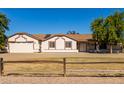 Front view of house with a large yard and wooden fence at 19208 E Appleby Rd, Queen Creek, AZ 85142