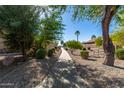 Landscaped pathway with mature trees and desert landscaping at 44043 W Cypress Ln, Maricopa, AZ 85138