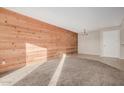 Living room featuring a wood-paneled wall and carpeted floors at 540 N May St # 1109, Mesa, AZ 85201