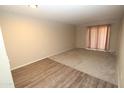 Bright living room with wood-look flooring and carpet, sliding glass doors to patio at 3119 W Cochise Dr # 106, Phoenix, AZ 85051