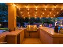 Outdoor kitchen with grill, sink, and countertop under a covered patio at 7801 E Davenport Dr, Scottsdale, AZ 85260