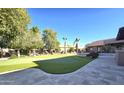Landscaped backyard with a putting green, patio, and pool at 7801 E Davenport Dr, Scottsdale, AZ 85260