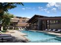 Relaxing pool area with lounge chairs and modern clubhouse at 19360 N 73Rd St # 1076, Scottsdale, AZ 85255