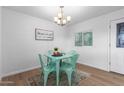 Charming dining area with light teal table and chairs, a chandelier, and a large piece of art at 332 W Palo Verde Dr, Superior, AZ 85173