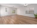 Bright living room featuring wood-look flooring and a large window at 45680 W Barbara Ln, Maricopa, AZ 85139