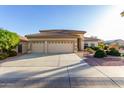 Beautiful home exterior with a three-car garage and well-manicured landscaping at 16513 W Windsor Ave, Goodyear, AZ 85395