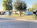 Ranch-style home with a spacious yard, mature trees, and a detached shed at 4936 E Coronado Rd, Phoenix, AZ 85008