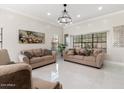 Spacious living room with beige sofas and a large chandelier at 16008 N 56Th Way, Scottsdale, AZ 85254