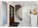 Bright entryway with a dark wood door, staircase, and white tile floors at 16008 N 56Th Way, Scottsdale, AZ 85254