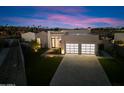 Stunning contemporary home with a flat roof and expansive windows at dusk at 6921 N Joshua Tree Ct, Paradise Valley, AZ 85253