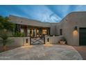 Elegant home exterior with a courtyard entrance at dusk at 10119 E Horizon Dr, Scottsdale, AZ 85262