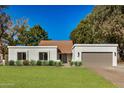 Single-story home with a brown tile roof, white stucco walls, and a two-car garage at 5310 E Kathleen Rd, Scottsdale, AZ 85254