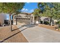 House exterior with two car garage and mature trees at 33970 N Cobble Stone Dr, San Tan Valley, AZ 85143