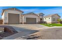 Modern home exterior with a three-car garage and artificial turf at 5170 N 186Th Dr, Litchfield Park, AZ 85340