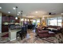 Open floor plan kitchen with dark cabinets and granite island at 26410 W Vista North Dr, Buckeye, AZ 85396