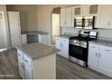 Modern kitchen with stainless steel appliances and white cabinets at 50599 W Esch Trl, Maricopa, AZ 85139