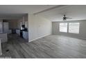 Spacious living room with wood-look floors and large windows at 50599 W Esch Trl, Maricopa, AZ 85139