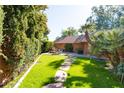 Landscaped backyard with a stone pathway, lush lawn, and a cozy fire pit area at 2026 E Pasadena Ave, Phoenix, AZ 85016