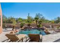 Inviting pool with waterfall feature, surrounded by lounge chairs and desert landscaping at 23461 N 80Th Way, Scottsdale, AZ 85255