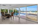 Bright dining room with large windows overlooking a sparkling pool and lake at 13626 N Tan Tara Pt, Sun City, AZ 85351