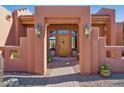 Elegant entryway with a wooden door and brick accents at 23461 N 80Th Way, Scottsdale, AZ 85255