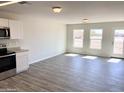 Bright and airy living room with wood-look floors and access to the backyard at 8572 W Raven Dr, Arizona City, AZ 85123