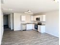 Open concept kitchen with white cabinets and stainless steel appliances at 8572 W Raven Dr, Arizona City, AZ 85123
