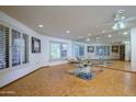 Spacious living room with hardwood floors and mirrored wall at 12842 W Ballad Dr, Sun City West, AZ 85375