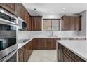 Well-equipped kitchen with dark wood cabinets and quartz countertops at 3535 E Melody Ln, Gilbert, AZ 85234